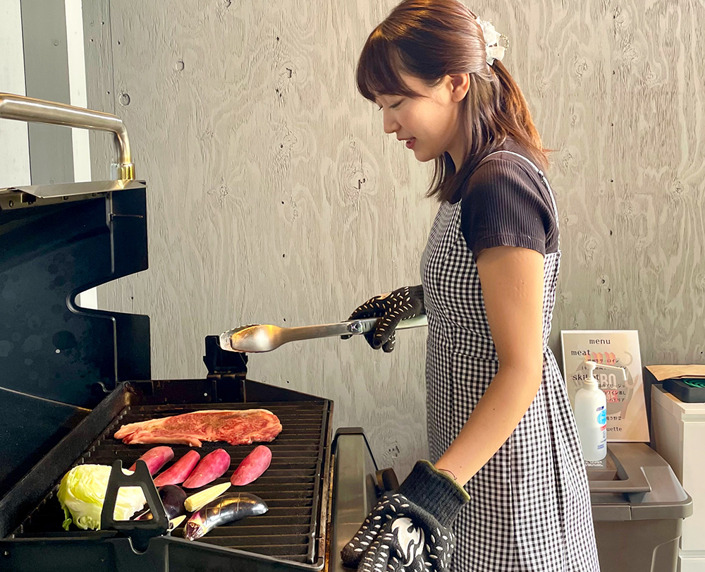 BBQコンロで食材を焼く女性